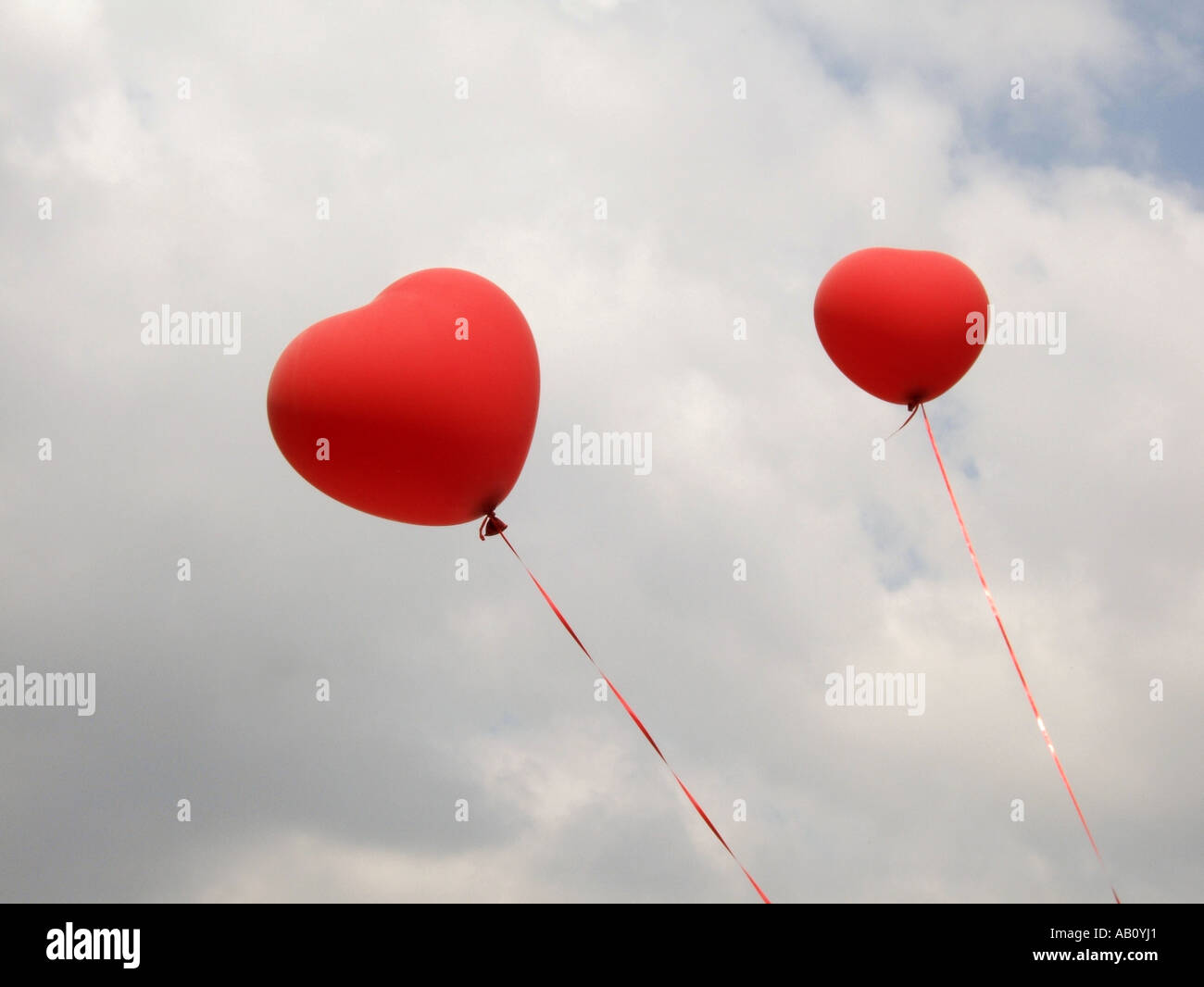 two heart shaped red balloons in blue sky Stock Photo - Alamy