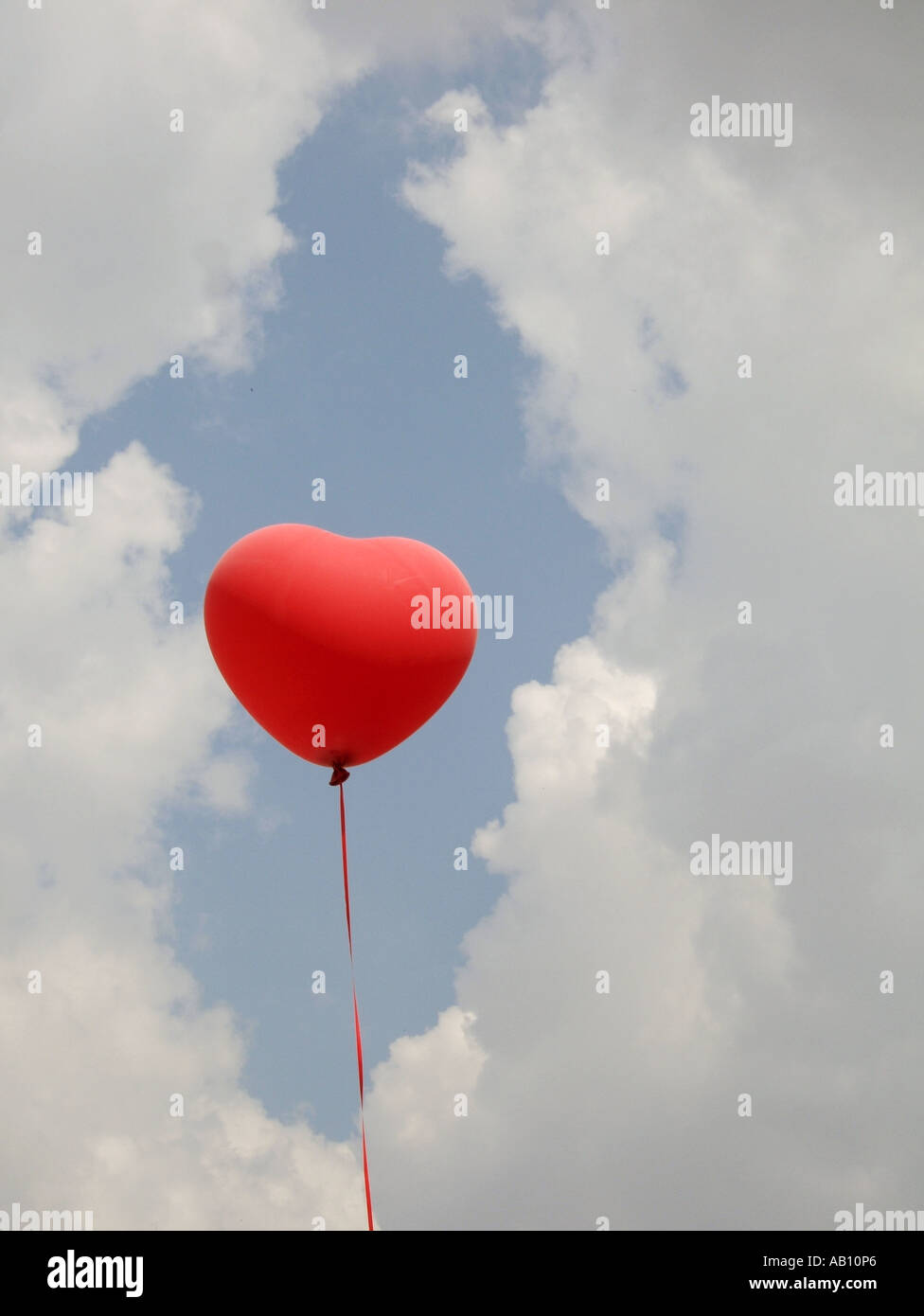 one heart shaped red balloon in blue sky Stock Photo - Alamy