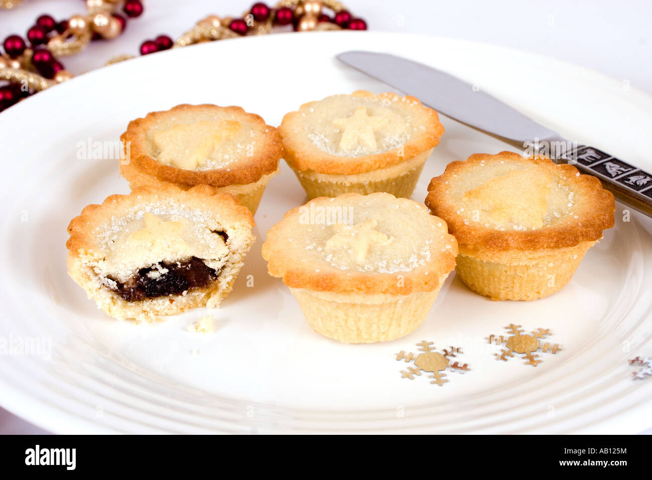 mince pies on a white plate with confetti stars and knife Stock Photo ...