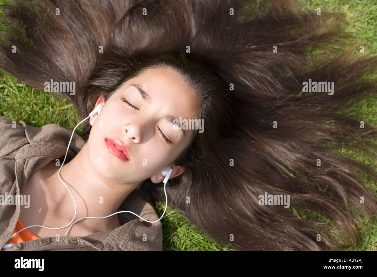 Teenage Girl Lying on Grass Listening to Music through Headphones Stock ...