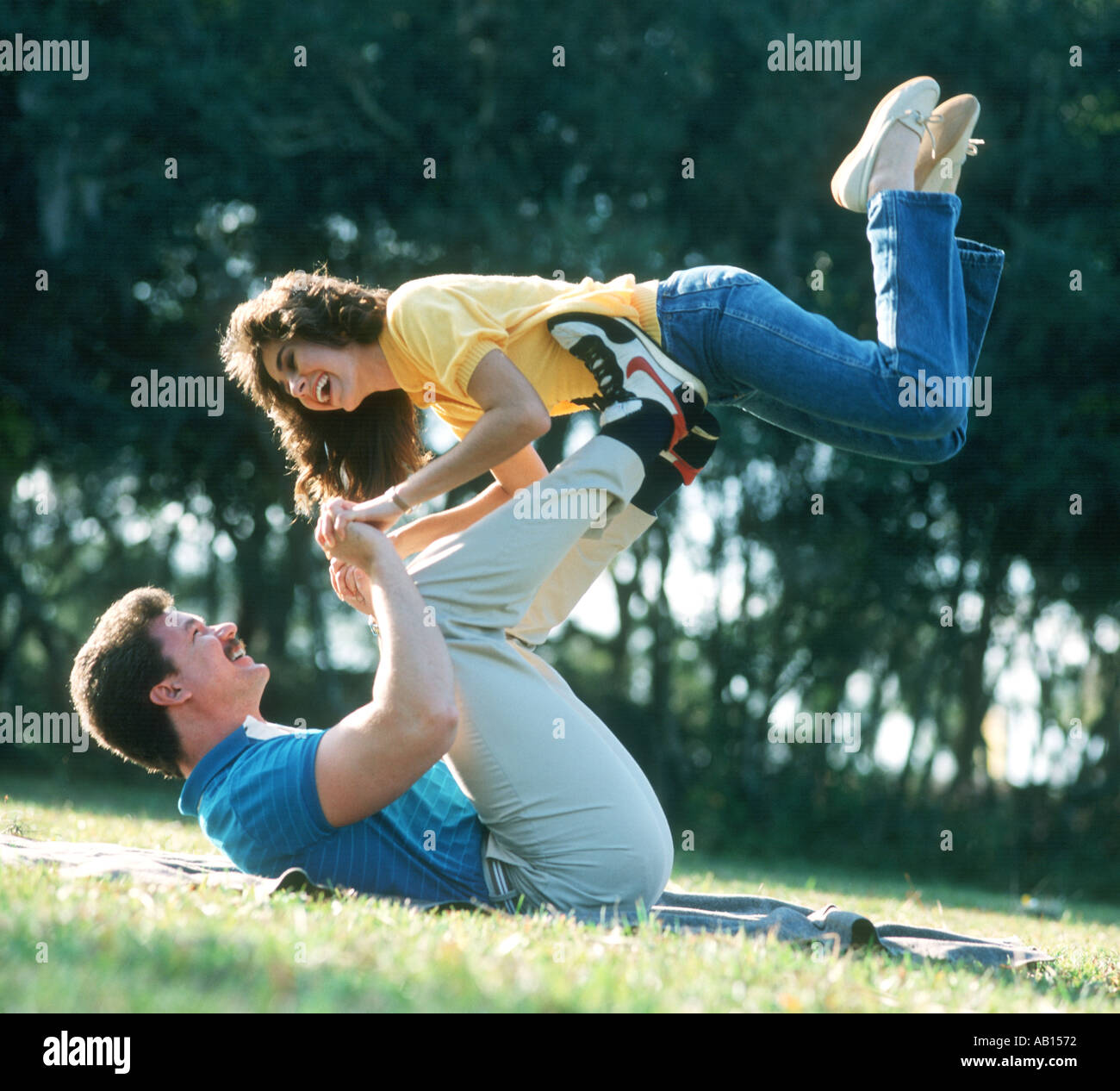 couple practicing gymnastics on grass in park Stock Photo