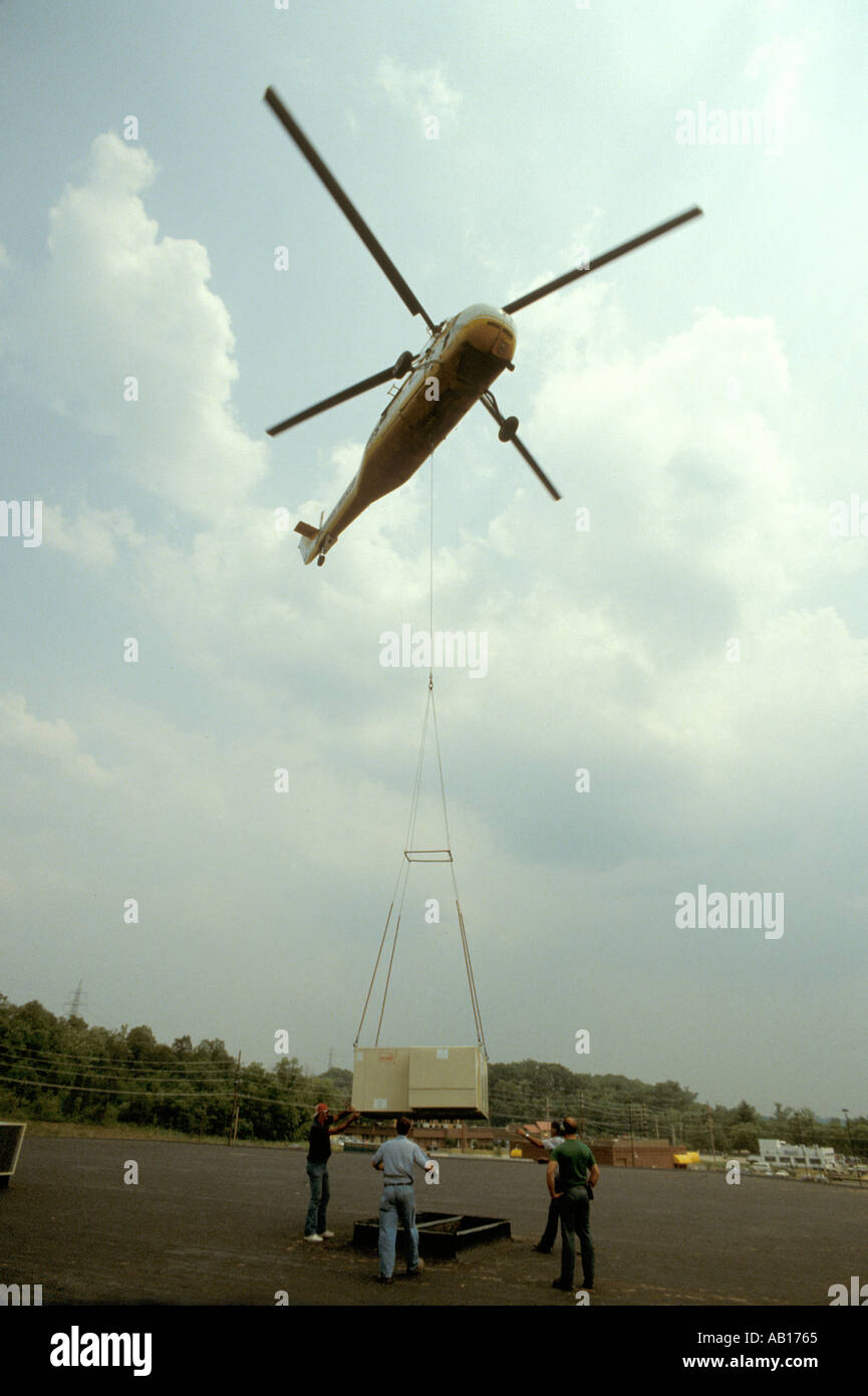 Sikorsky helicopter crane lifting an air conditioning unit on to the