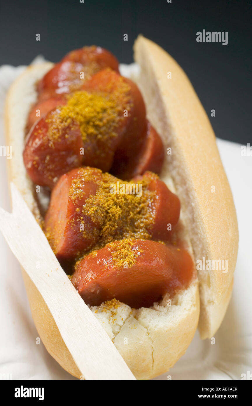 Currywurst sausage with ketchup curry powder in roll in paper dish