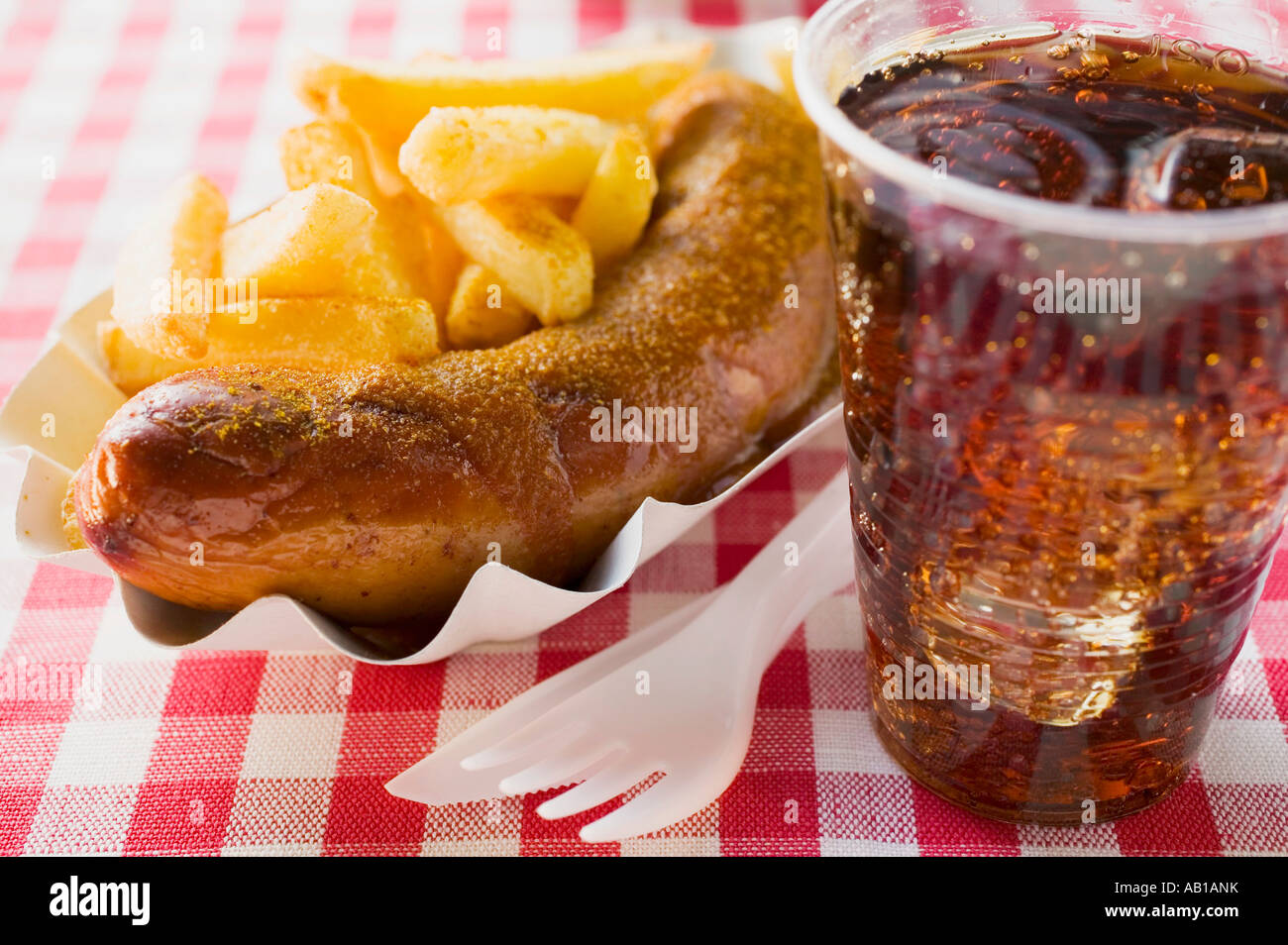 Sausage with ketchup curry powder chips cola in restaurant