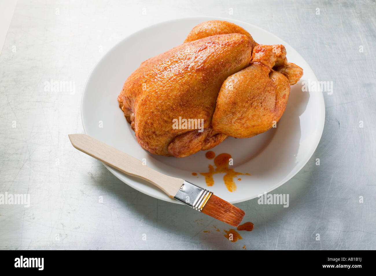 Fresh marinated chicken with basting brush FoodCollection Stock Photo