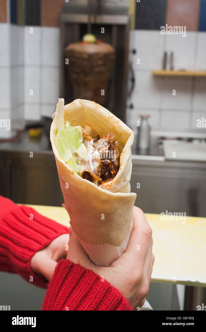 Hands holding döner wrap in snack bar FoodCollection Stock Photo - Alamy