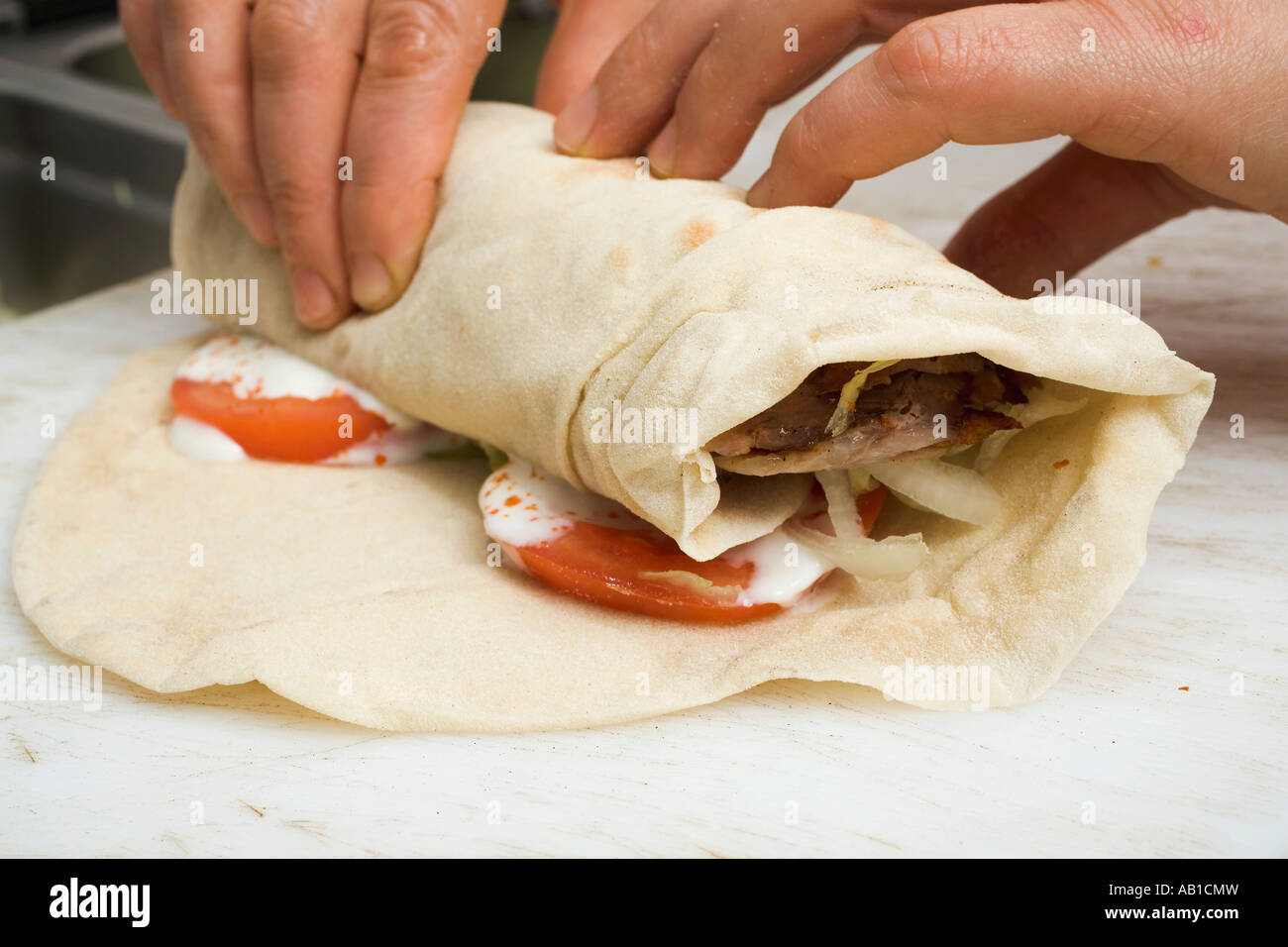 Making a döner wrap rolling up FoodCollection Stock Photo - Alamy