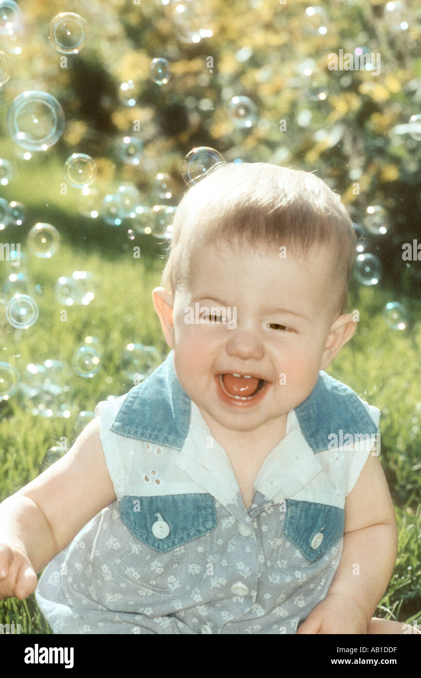 Baby catching bubbles outdoors Stock Photo