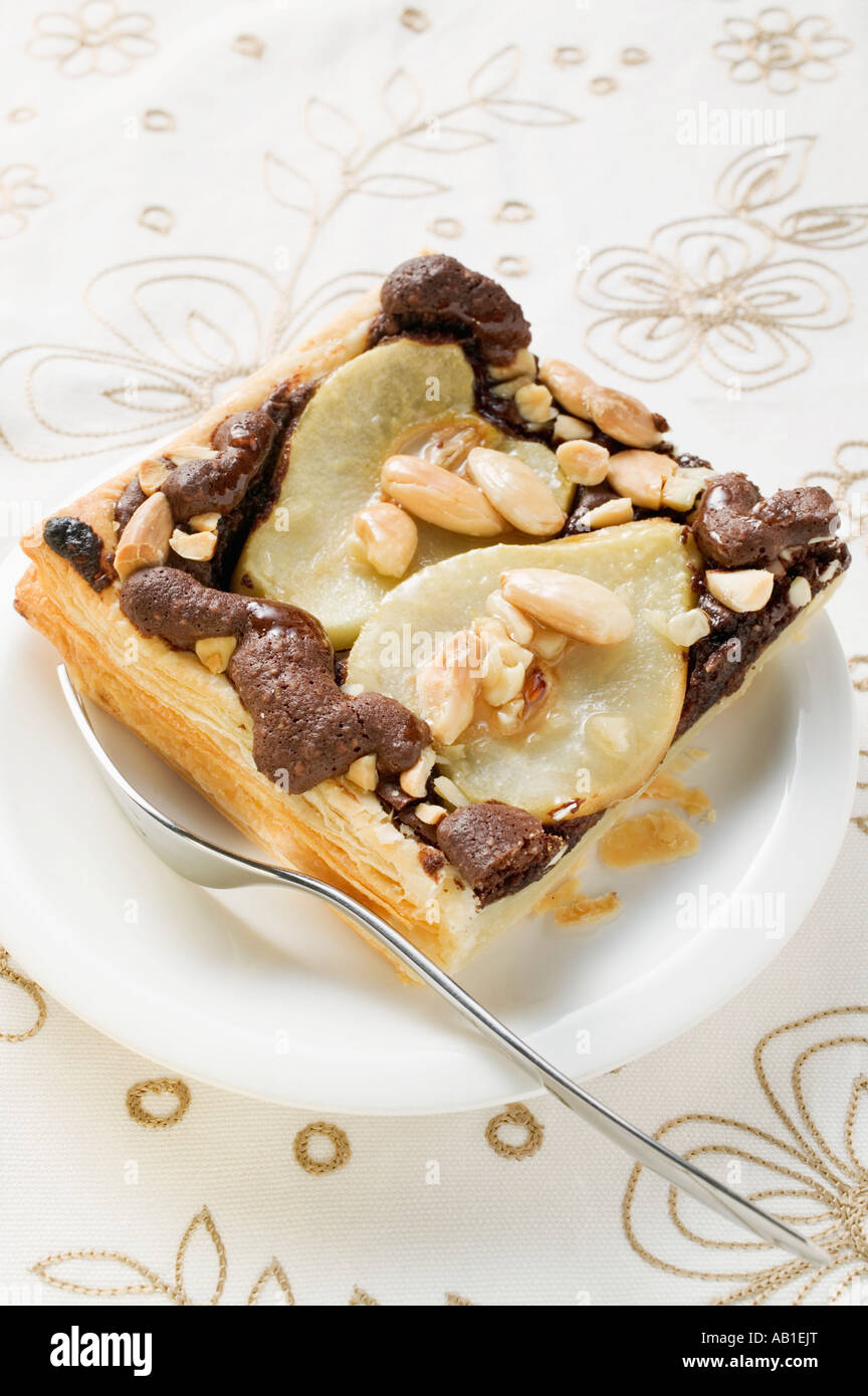 Piece of pear and chocolate tart with almonds on plate FoodCollection Stock Photo