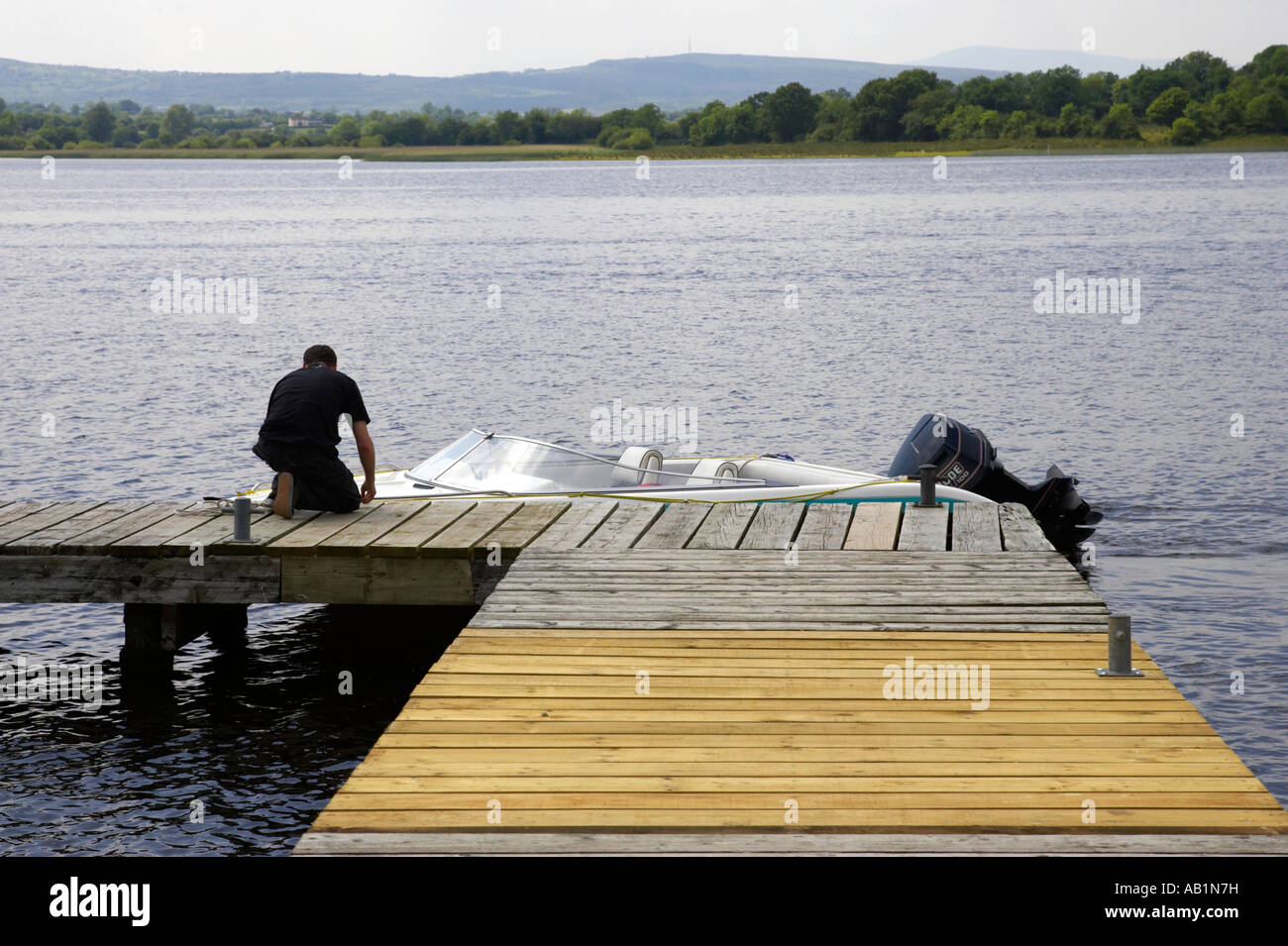 man ties speedboat up to corradillar public jetty upper lough erne Stock Photo