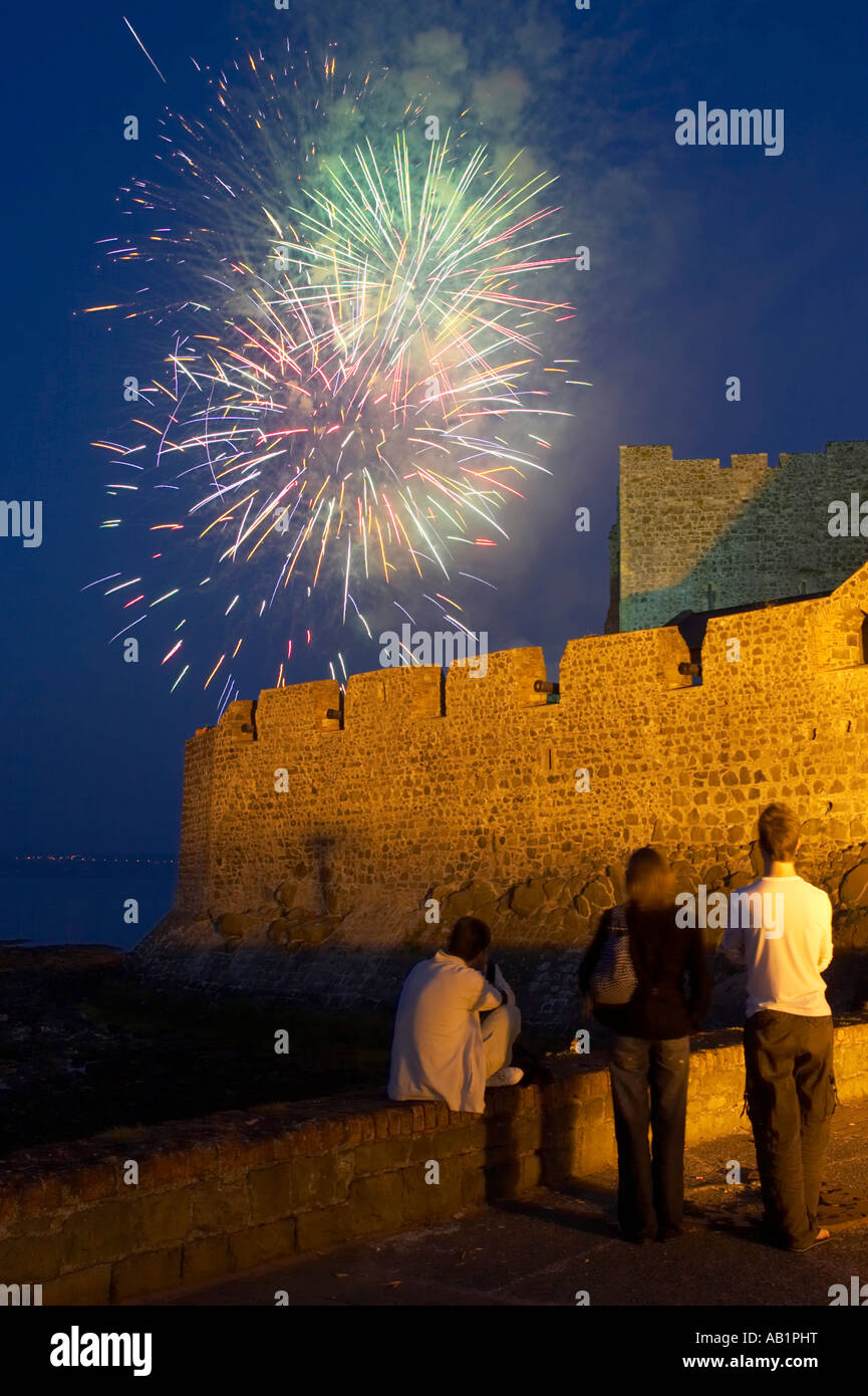 firework display above the walls of carrickfergus castle watched by small group of tourists Stock Photo