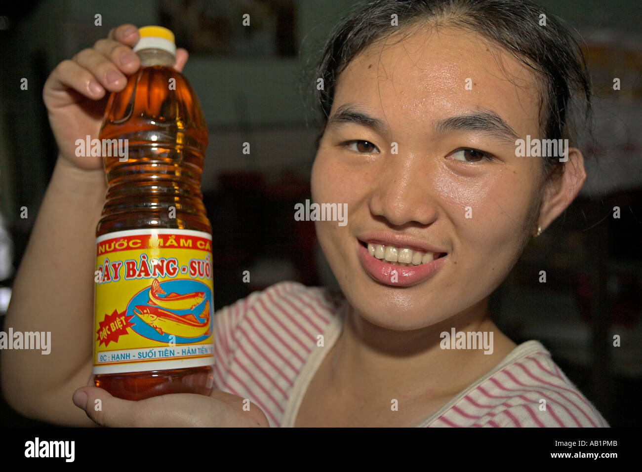 Young woman hold bottle of nuoc mam fermented fish sauce used widely in Vietnamese cooking. Stock Photo