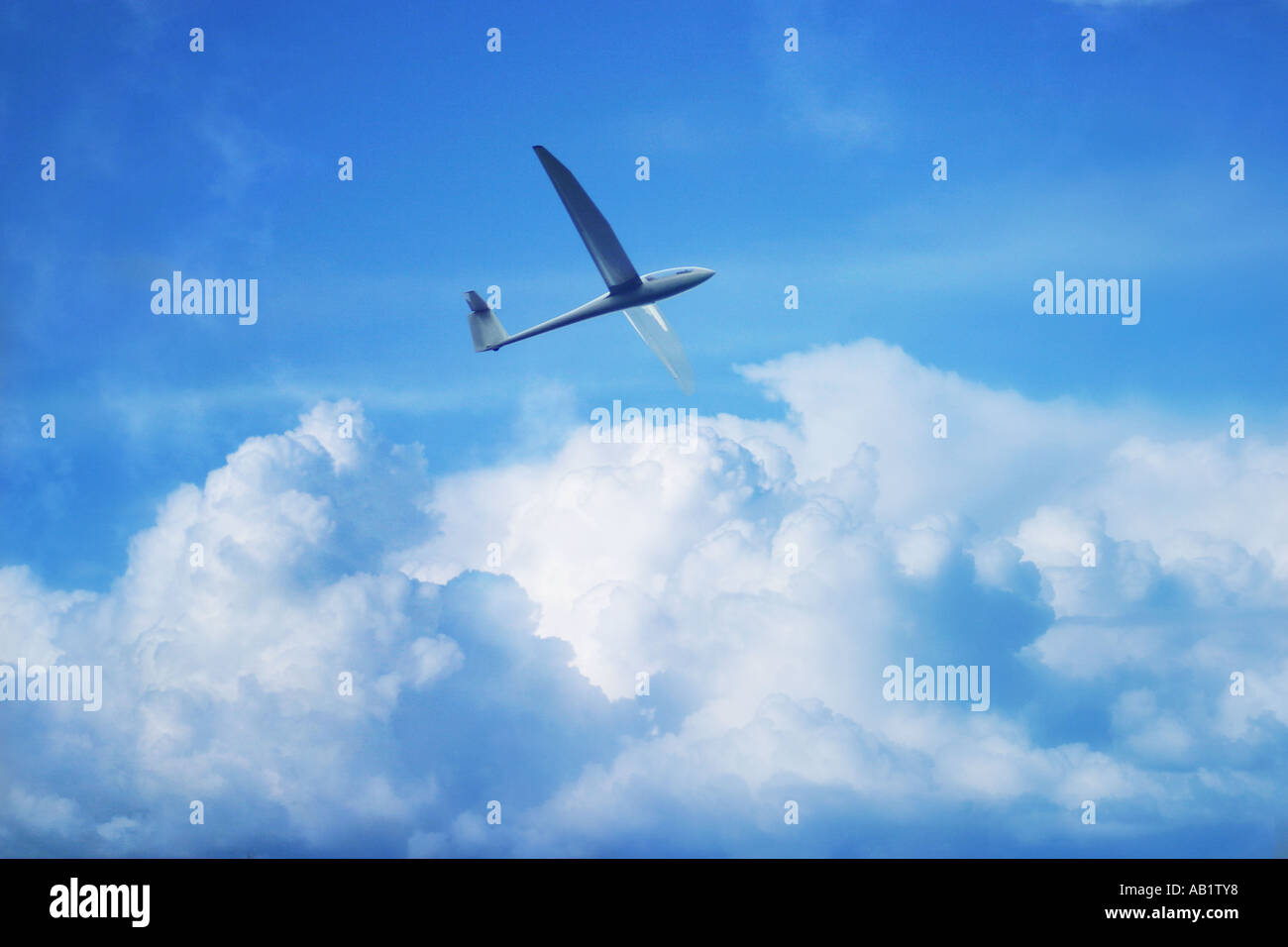a glider flying above the clouds Stock Photo