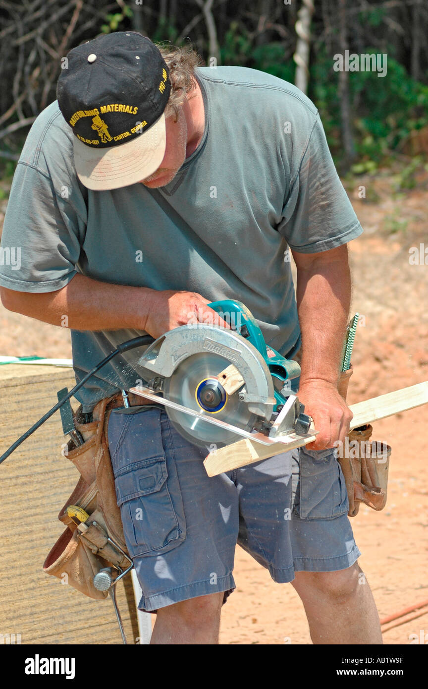 Unsafe cutting wood frame home construction by workers stick built