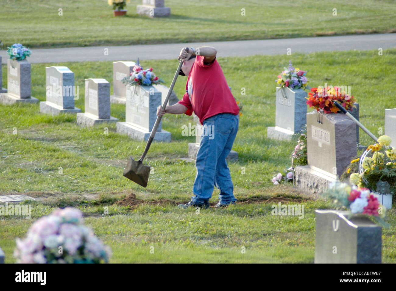 Man digging a grave by hand in America in cemetery for later that day