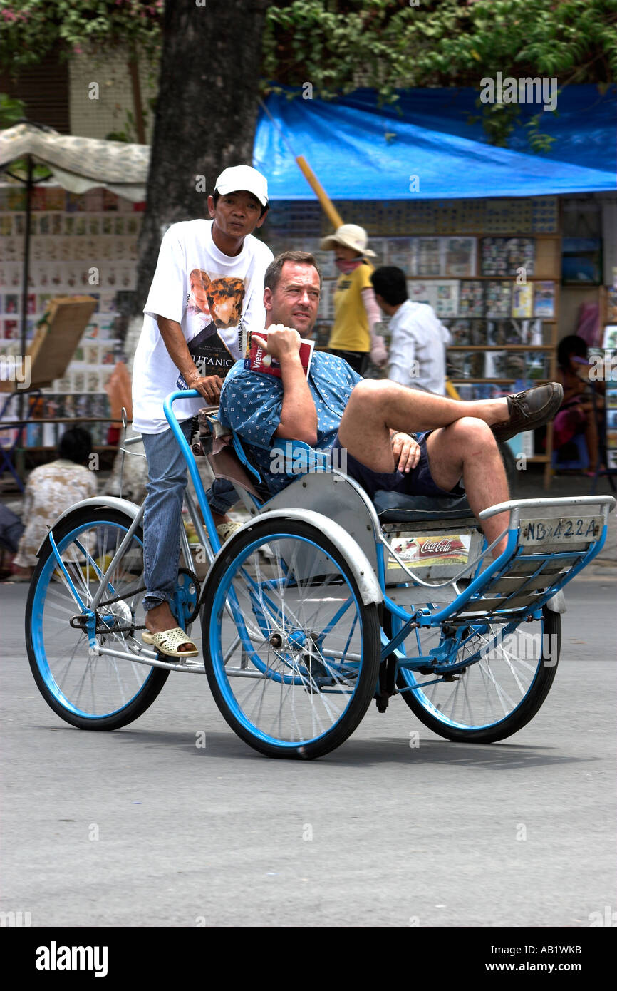 Male visitor tours Ho Chi Minh City by cyclo rickshaw Vietnam Stock Photo