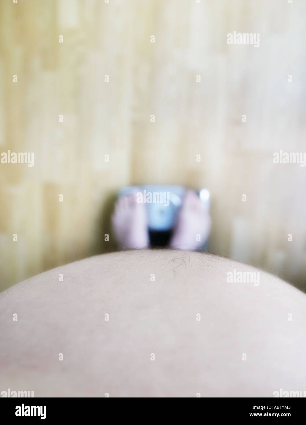 A fat man standing on scales Stock Photo