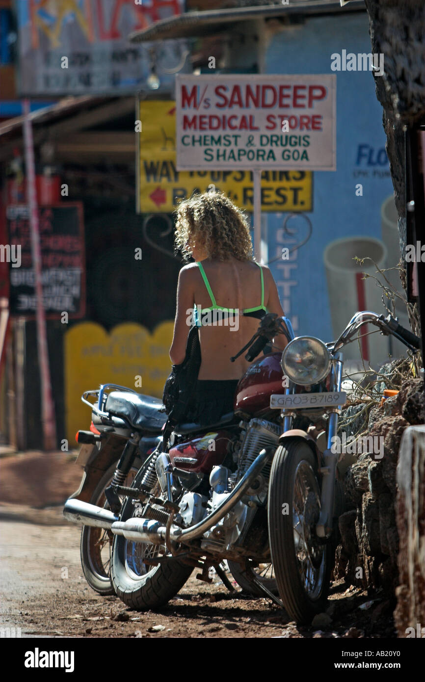 Bikini top woman in mini skirt sits on old Royal Enfield motorcycle Chapora  Village near Vagator Goa India Stock Photo - Alamy