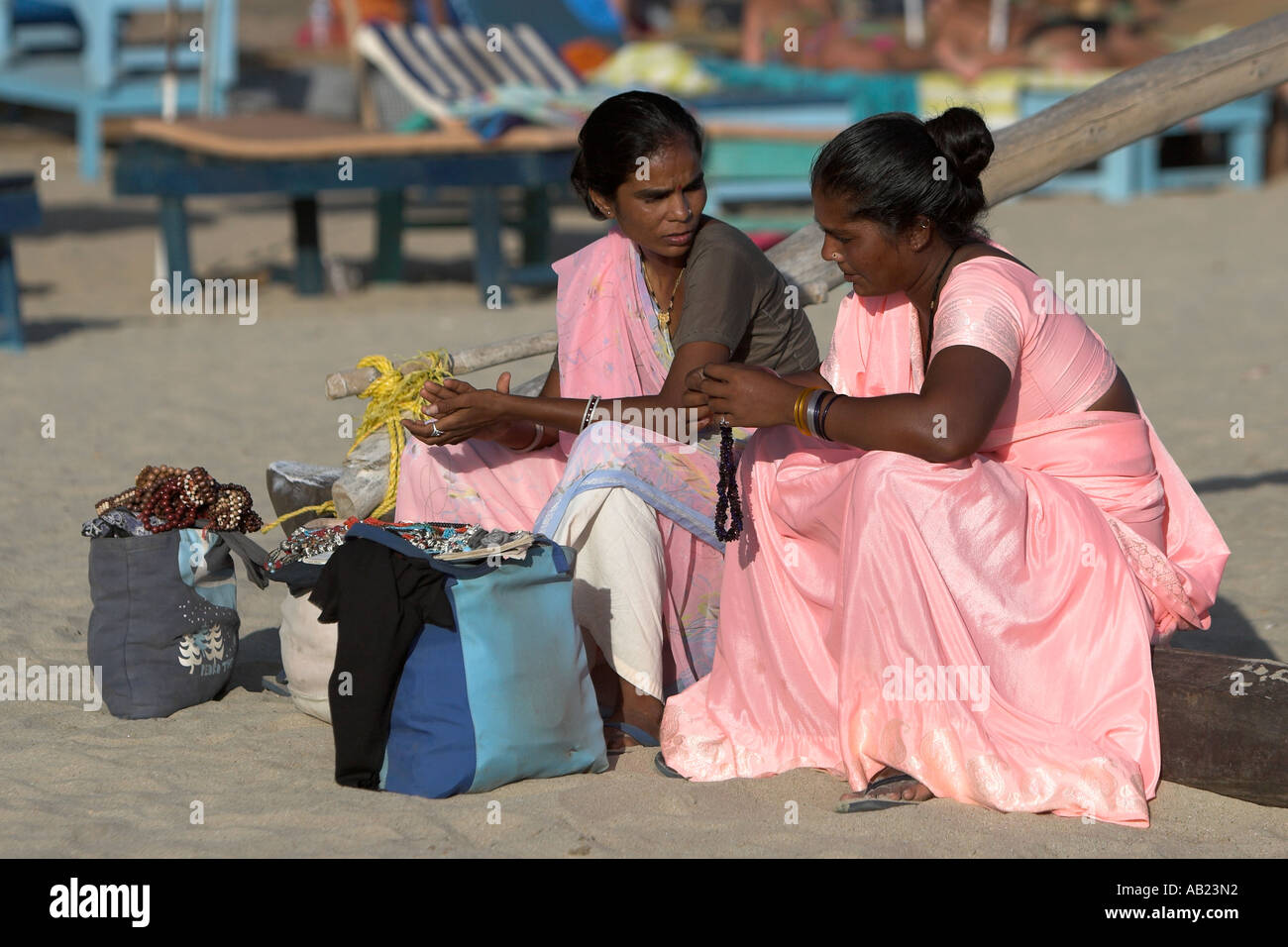 Women beach vendors in pink saris take a break Palolem south Goa India Stock Photo