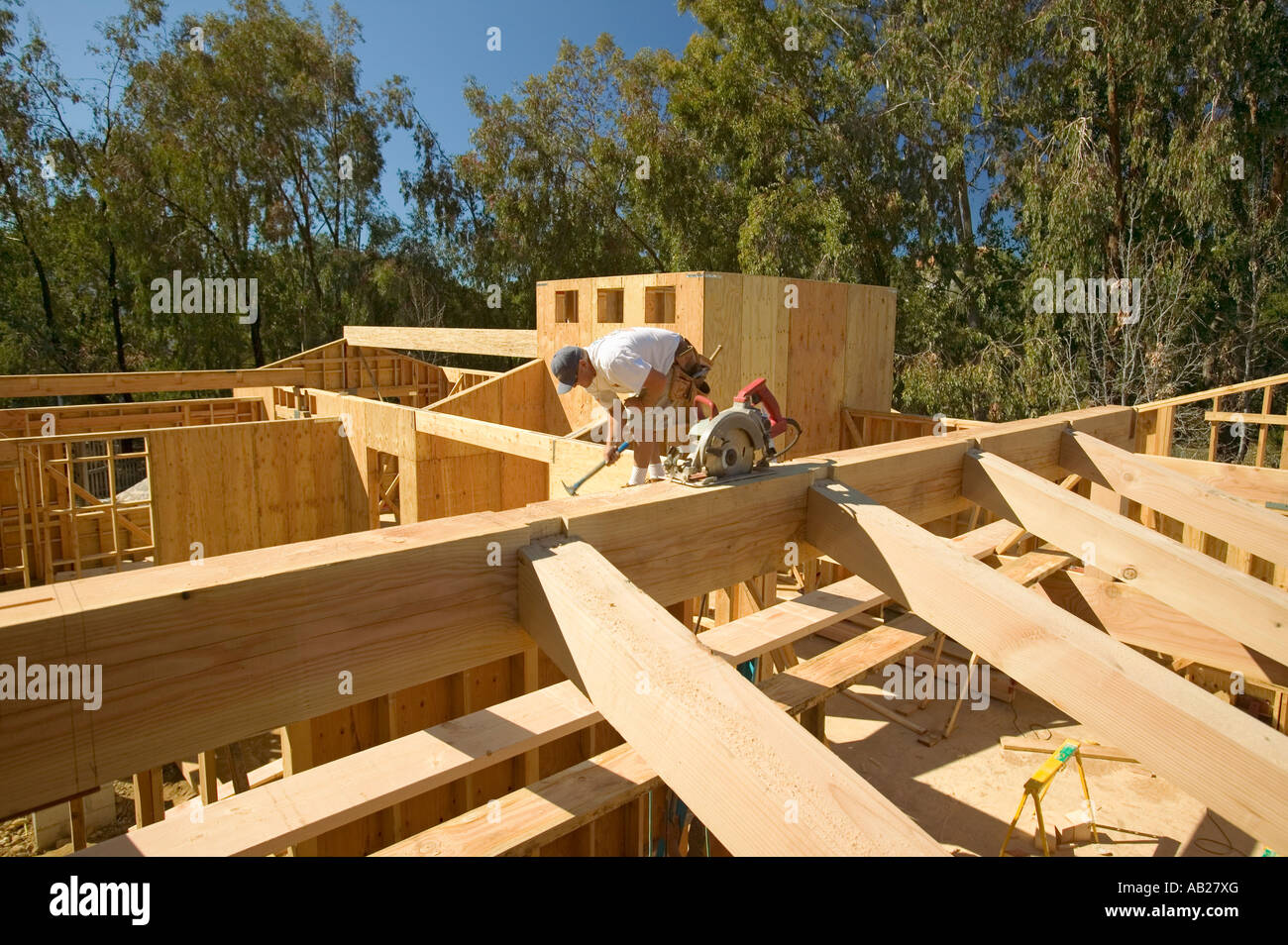 Carpenter hammers nails into central beam of framing process in