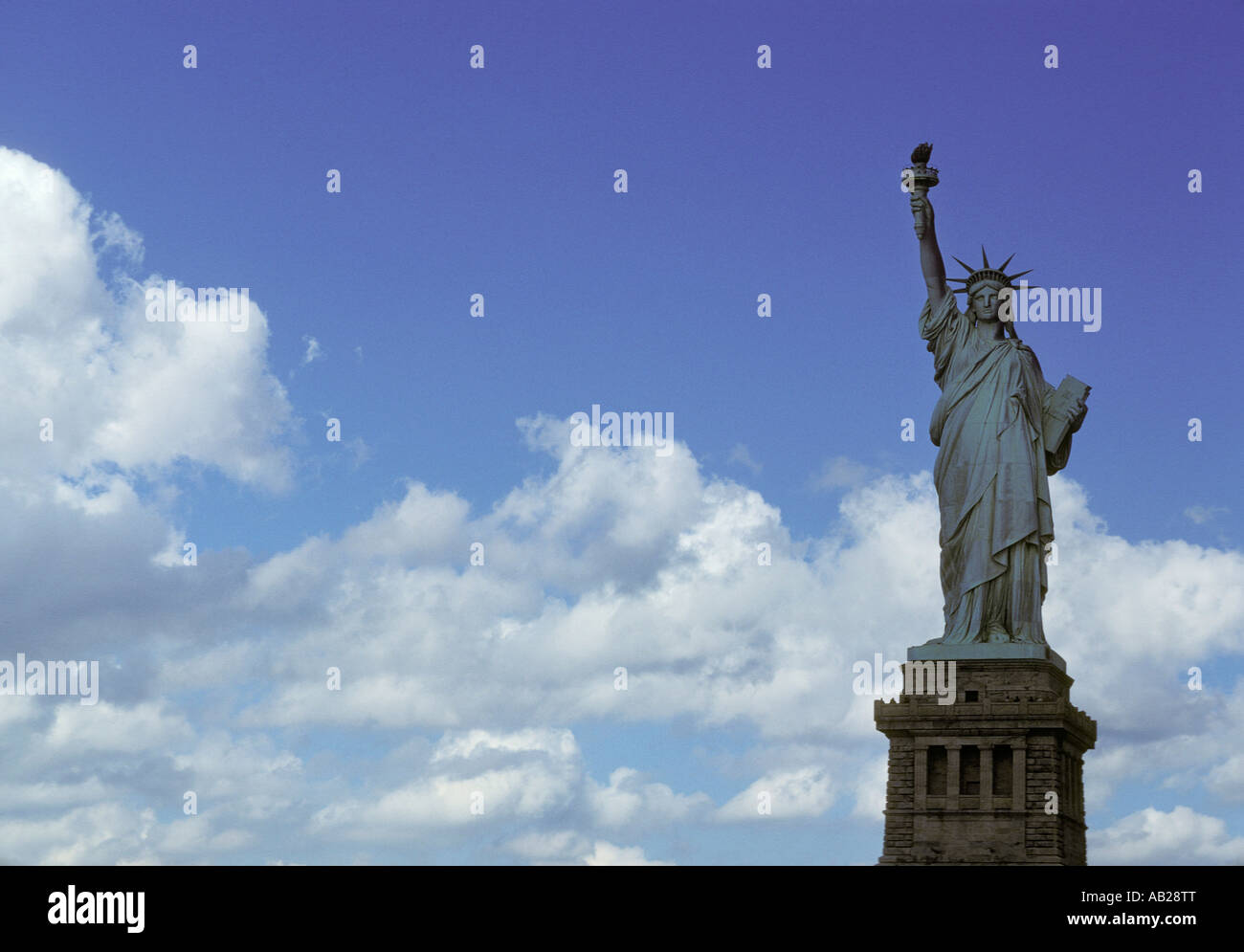 NYC Statue of Liberty New York Harbor New York city USA America Americana bright white fluffy clouds Stock Photo