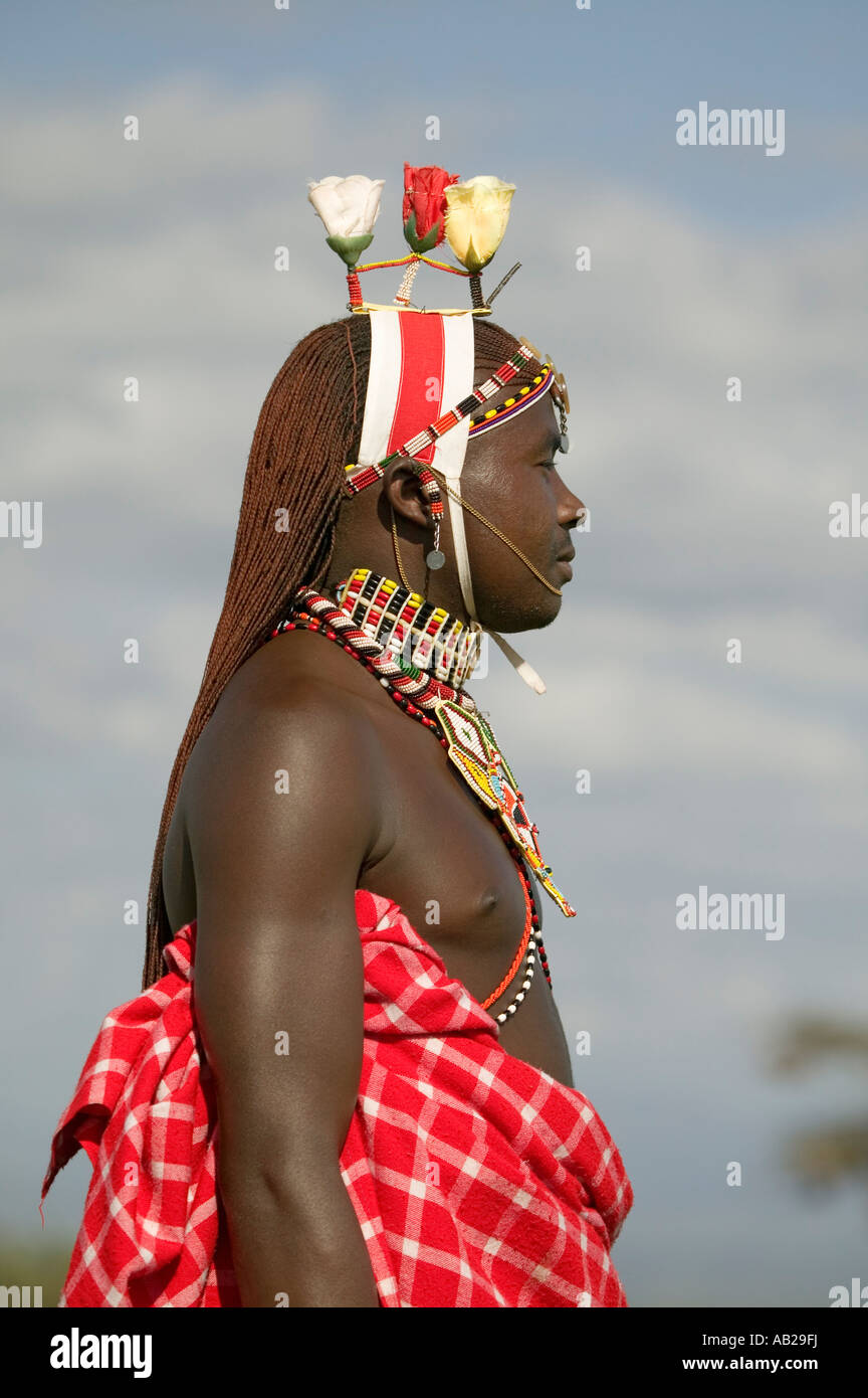 Portrait Of Masai Warrior In Traditional Red Toga And Flowers On His Head At Lewa Wildlife