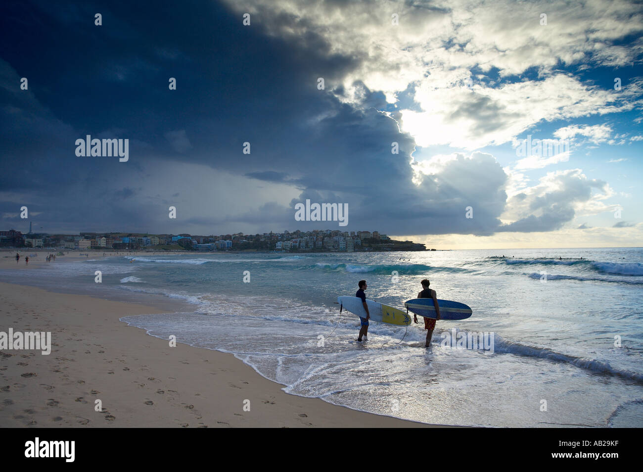 two surfers entering the water on Bondi Beach early morning Sydney New South Wales Australia Stock Photo