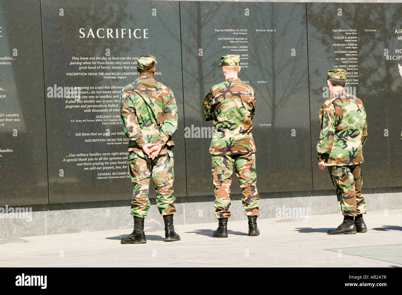 Three servicemen look at granite inscription on wall of Air Force Memorial Arlington Virginia in Washington D C area Stock Photo
