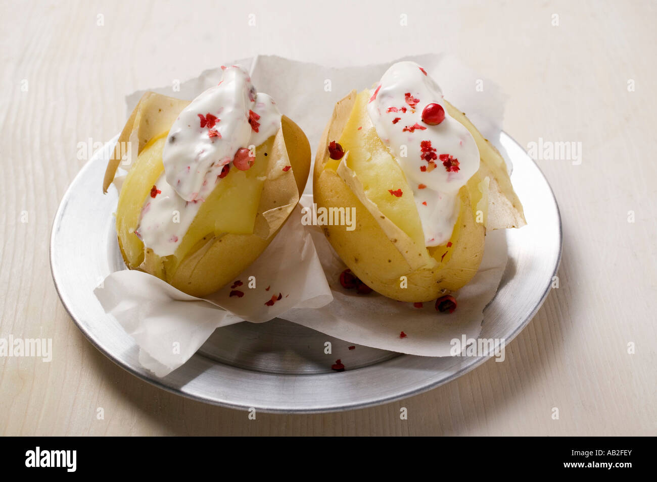 Potatoes cooked in their skins with sour cream red pepper FoodCollection Stock Photo