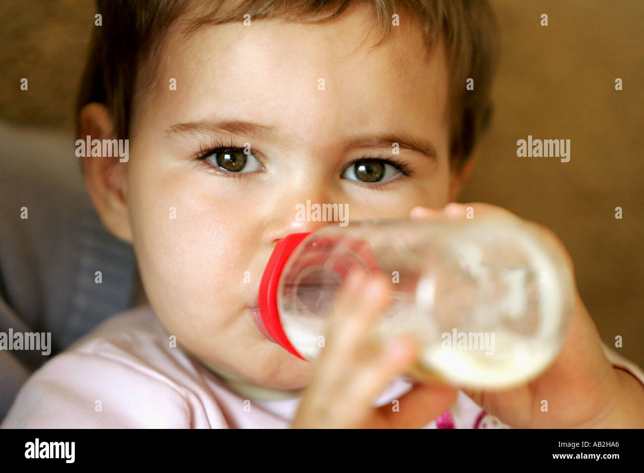 bottle fed baby girl baby milk drink drinking looking look black eyes
