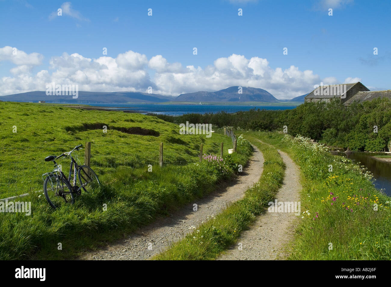 dh Scottish islands cycling BAY OF IRELAND ORKNEY SCOTLAND Bicycle remote cycle parked country side scene quiet track bicycles field summer Stock Photo