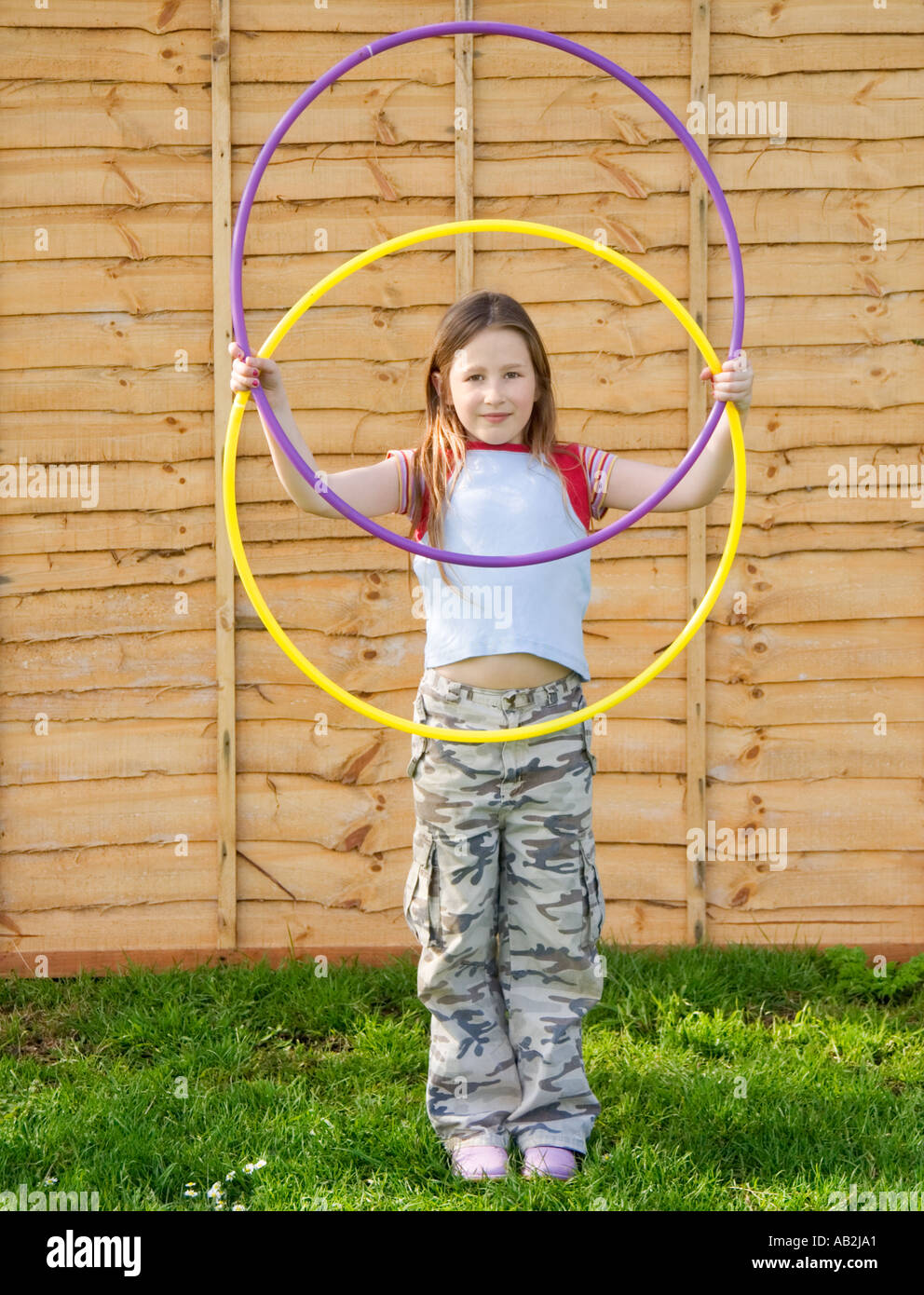 Girl holding two plastic hula hoops Stock Photo