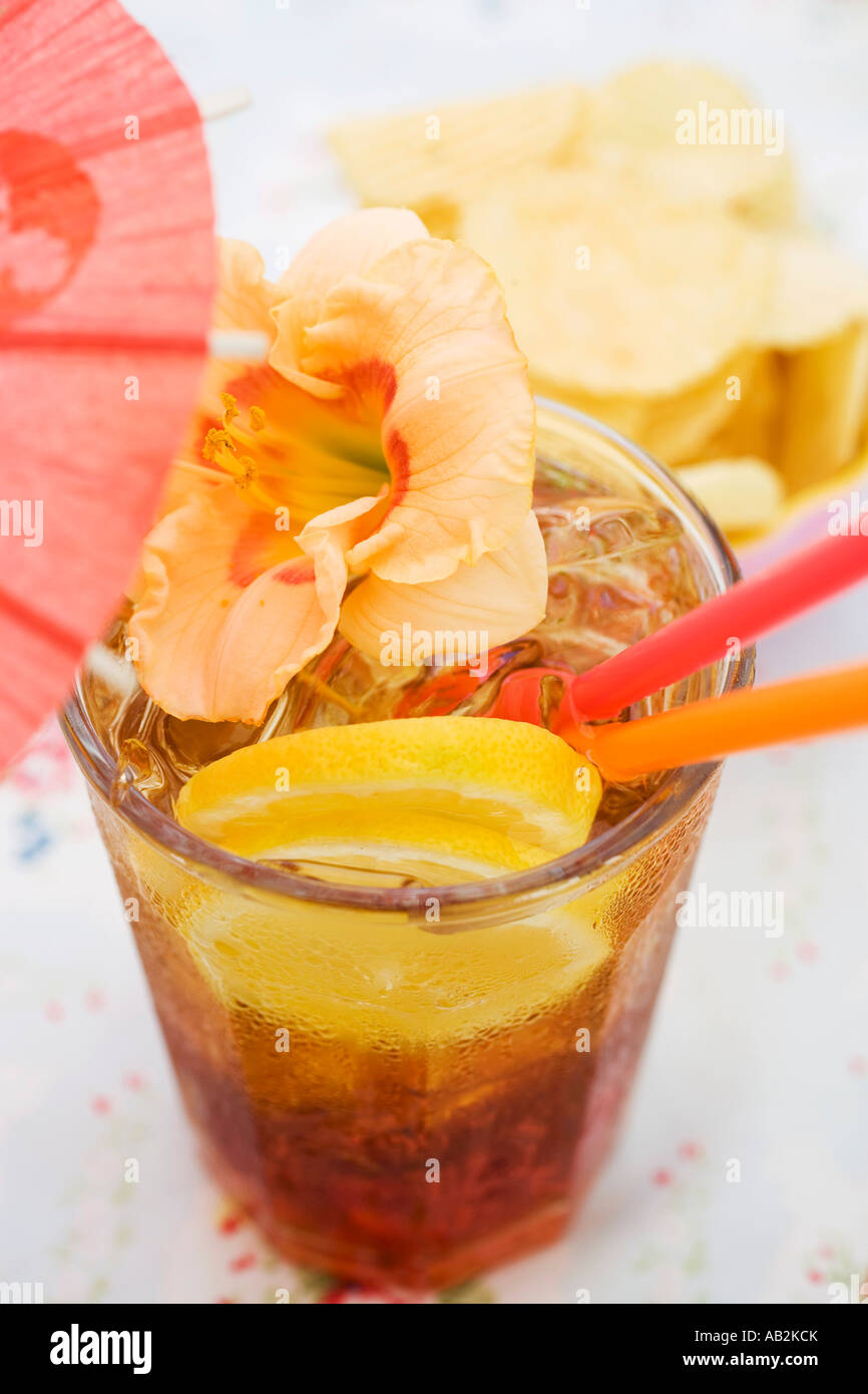 Cuba Libre with cocktail umbrella and amaryllis flower FoodCollection Stock Photo