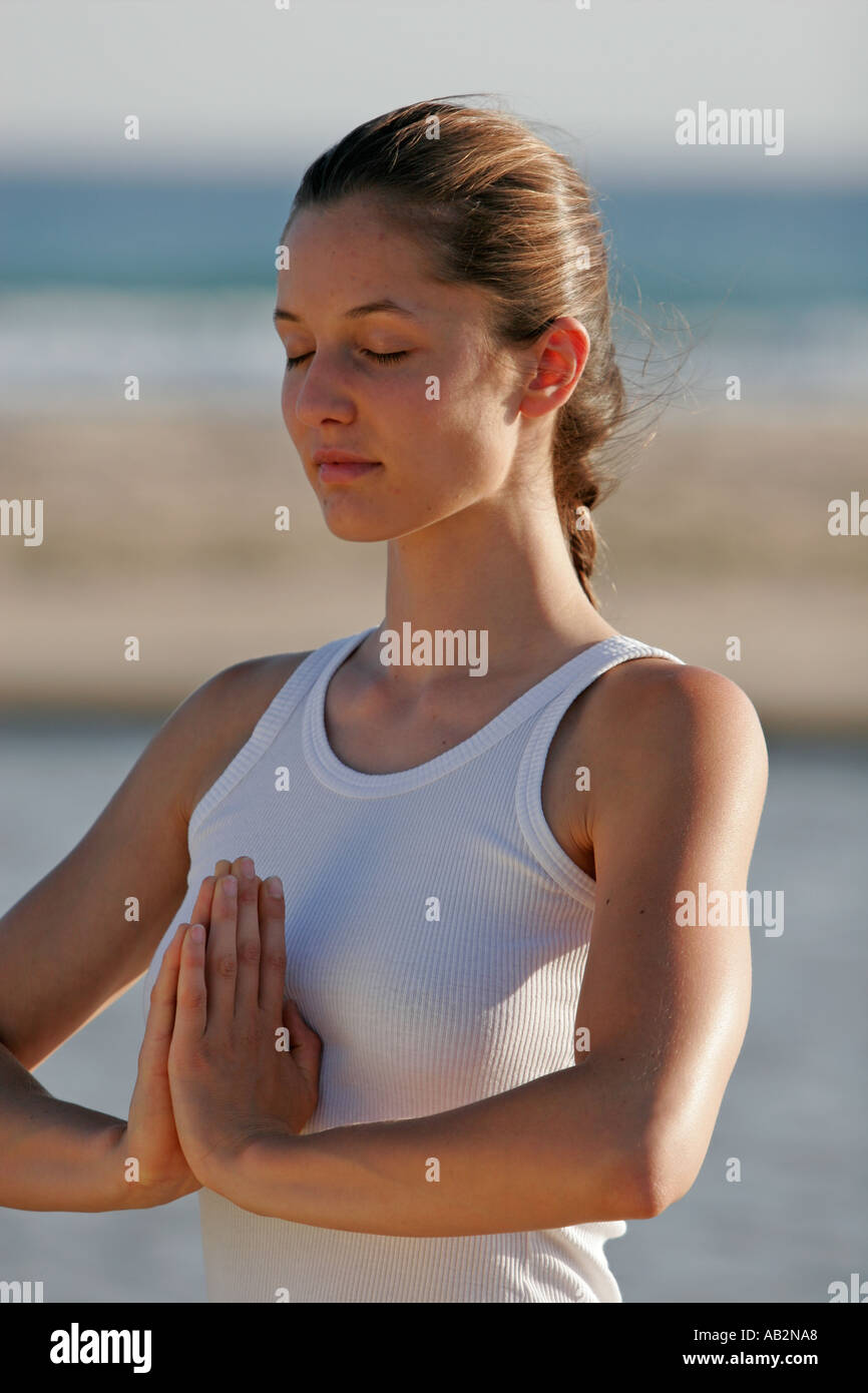 Woman on beach practising Yoga Stock Photo