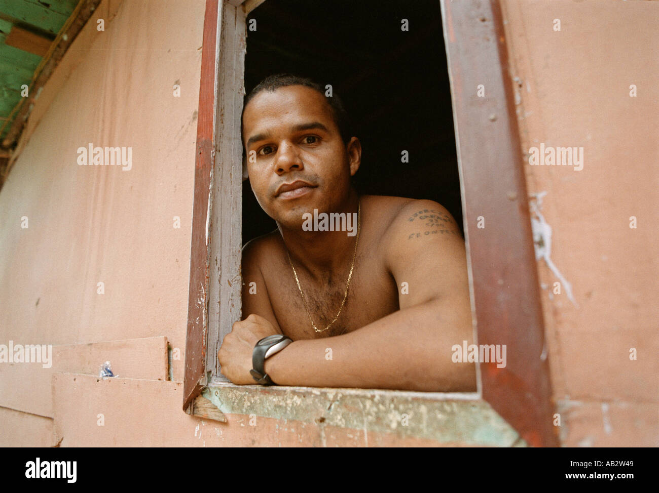 Resident of the hillside squatter settlement of Ezequiel Zamora in Caracas Venezuela poses in the window of his plywood house Stock Photo