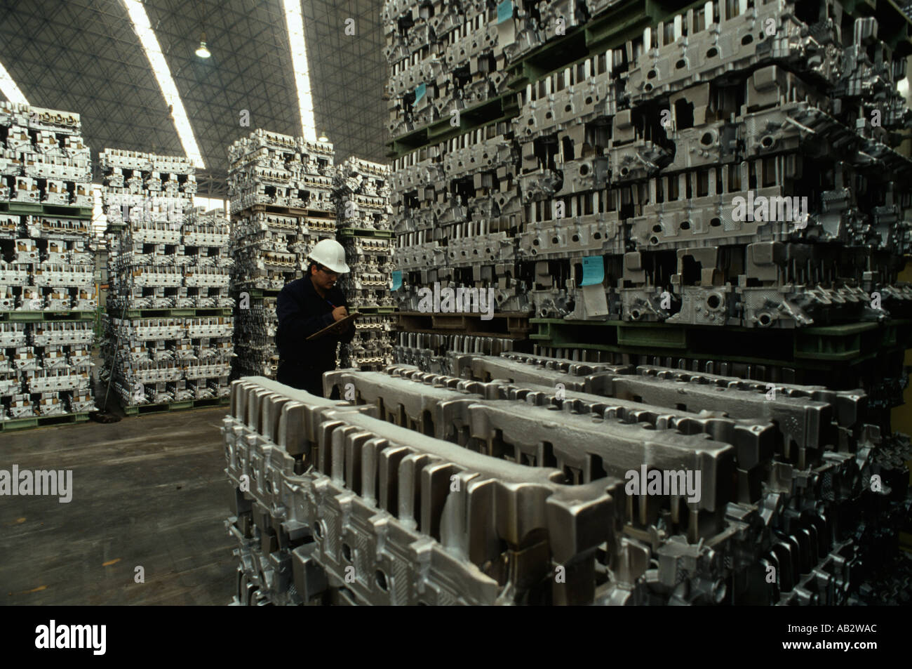 A warehouse worker checks the inventory of automobile engine blocks manufactured at the Nemak plant in Monterrey Mexico  Stock Photo