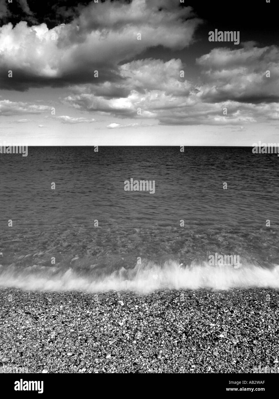 Slapton Sands South Devon in black and white with breaking waves and white cloud Stock Photo