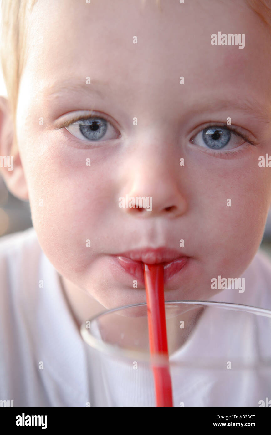 Two year old boy drinking from straw Stock Photo Alamy