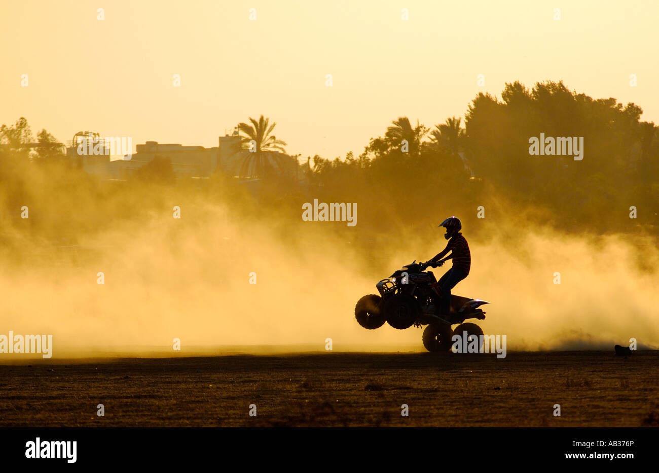 Israel Negev A silhouette of an All Terrain Vehicle ATV raising dust at sun set Stock Photo