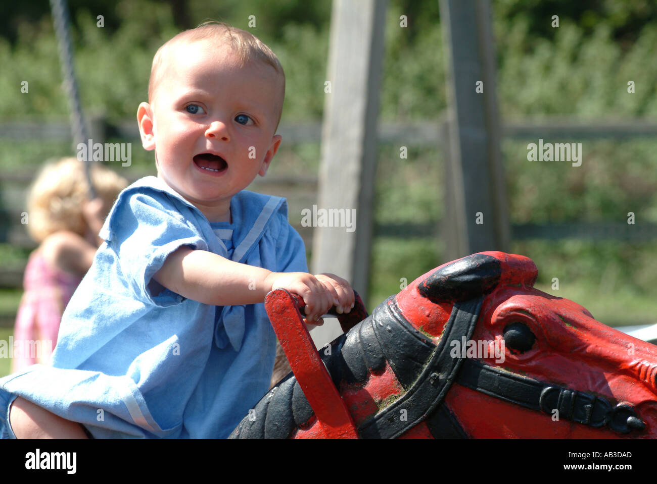 Baby Riding Roster Baby on horse ride in playground Stock Photo - Alamy