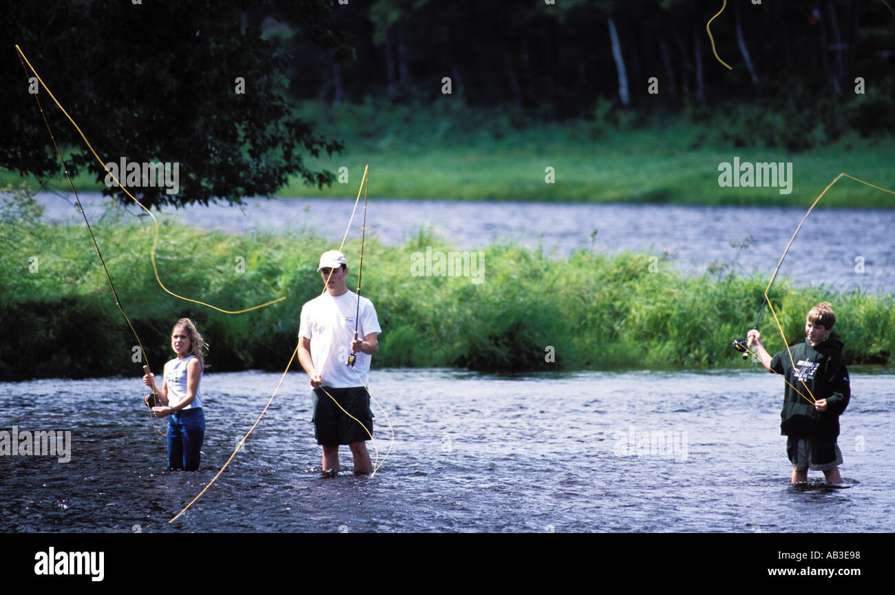three children learning to fly fish for salmon on the Miramichi River New Brunswick Canada Stock