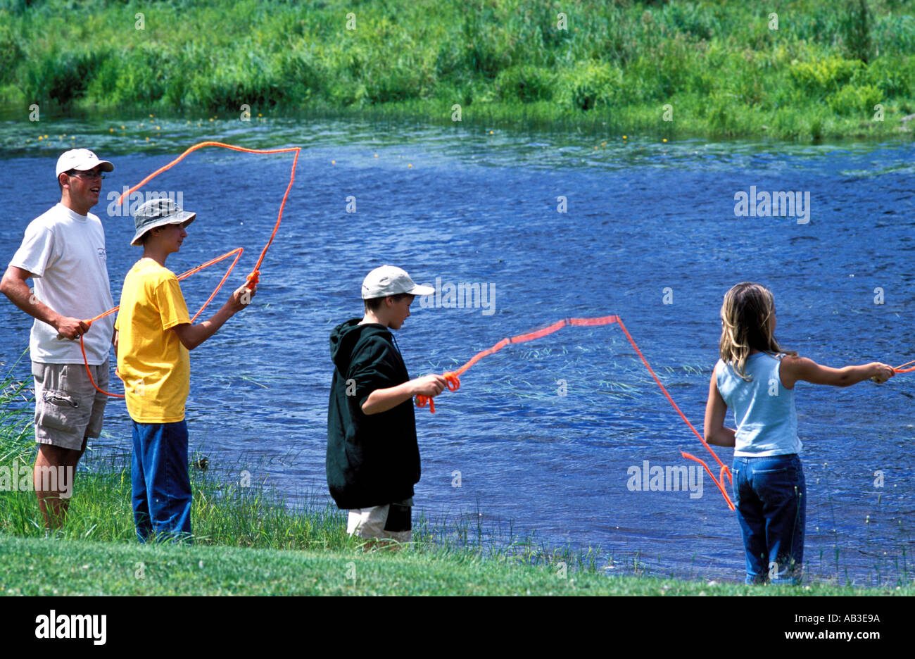 three children learning to fly fish for salmon on the Miramichi River New Brunswick Canada Stock