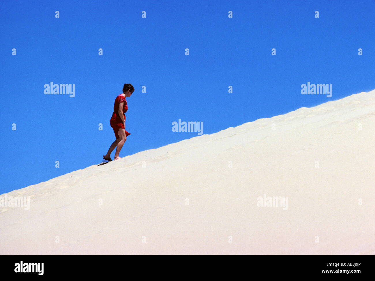 Woman Climbing a sand dune Stock Photo - Alamy