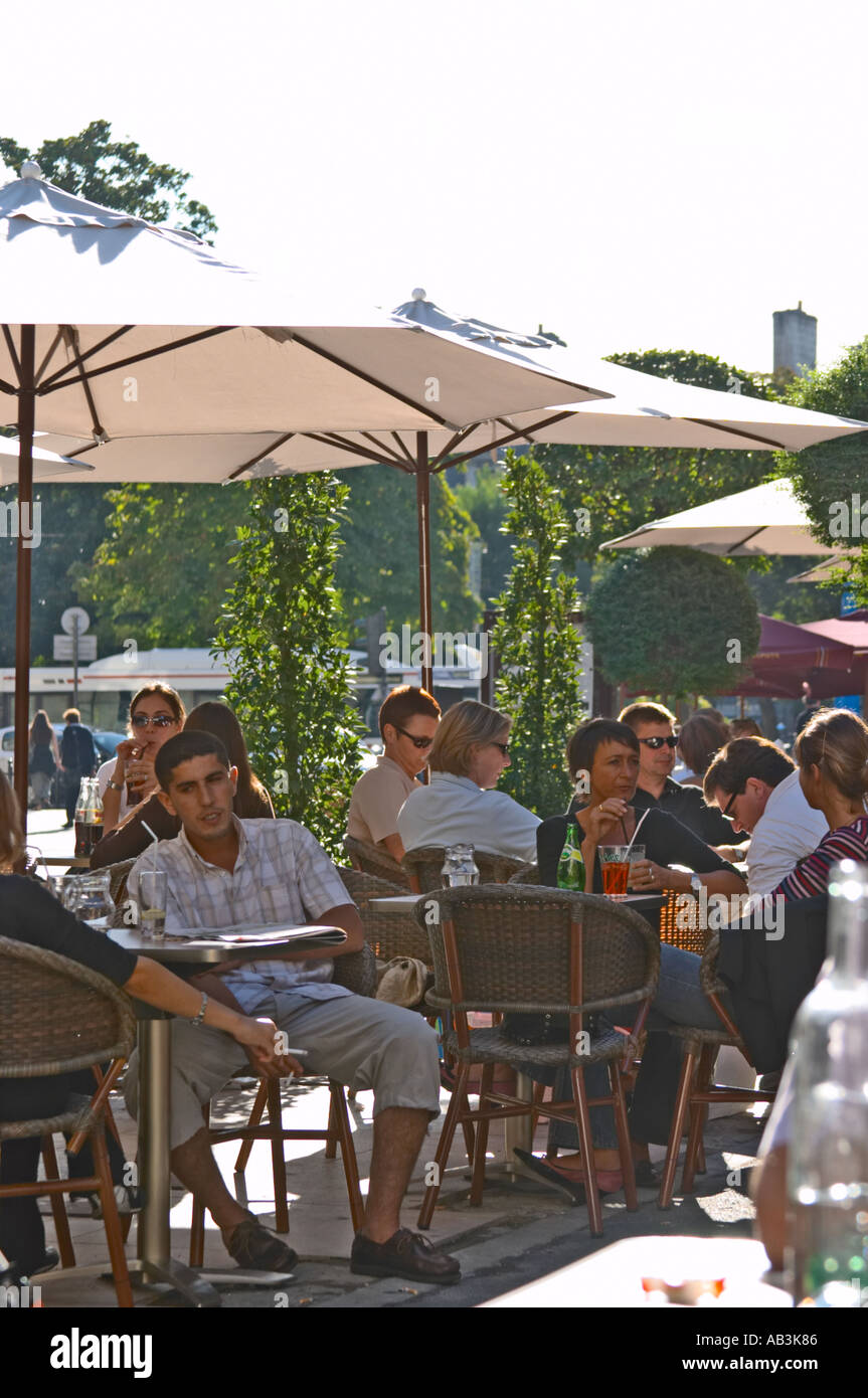 A cafe in Bordeaux city, outside seating terrasse with sun shades parasol,  people drinking and eating Stock Photo - Alamy