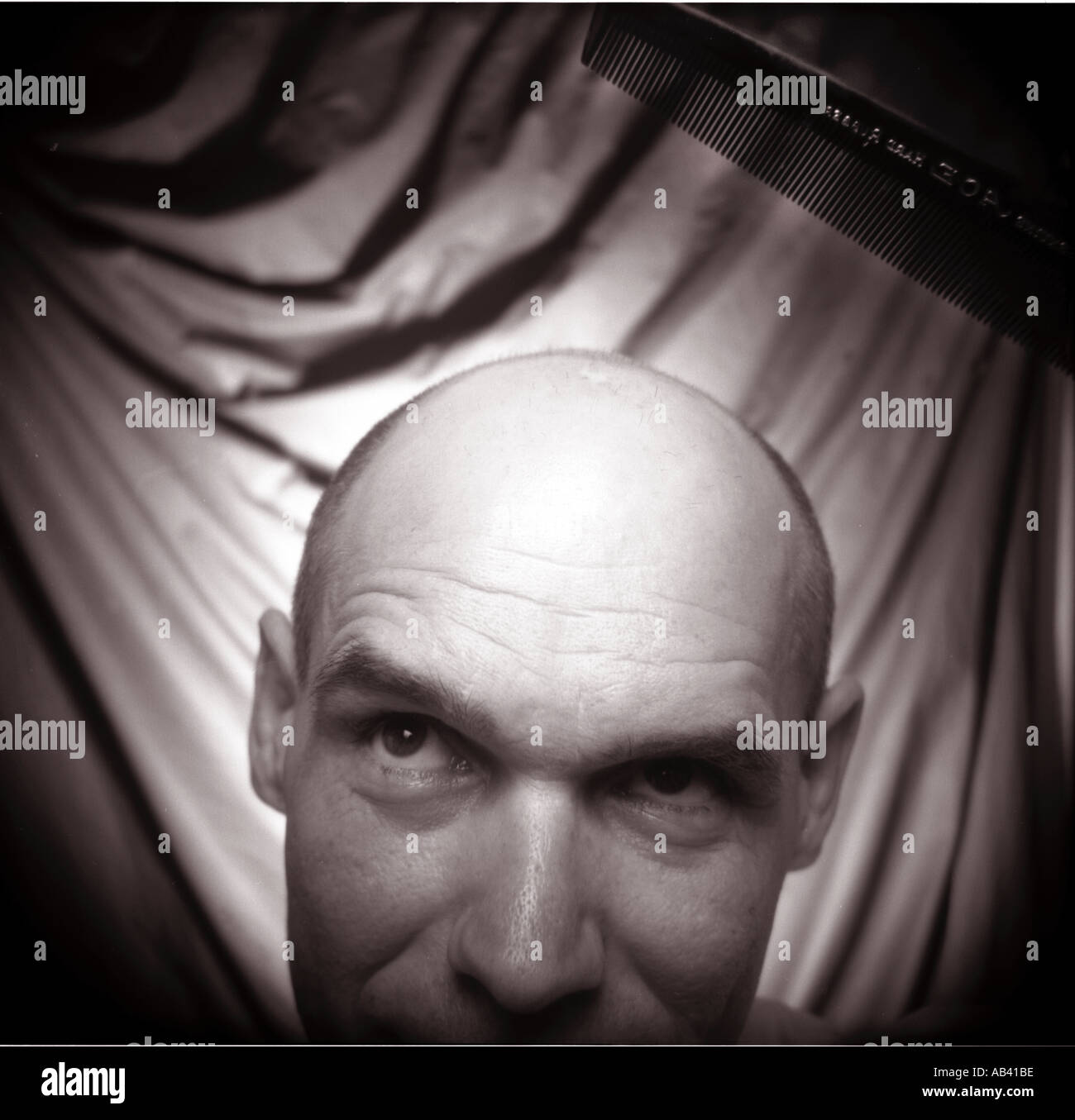 Bald man combing his last strand of hair Humor Stock Photo