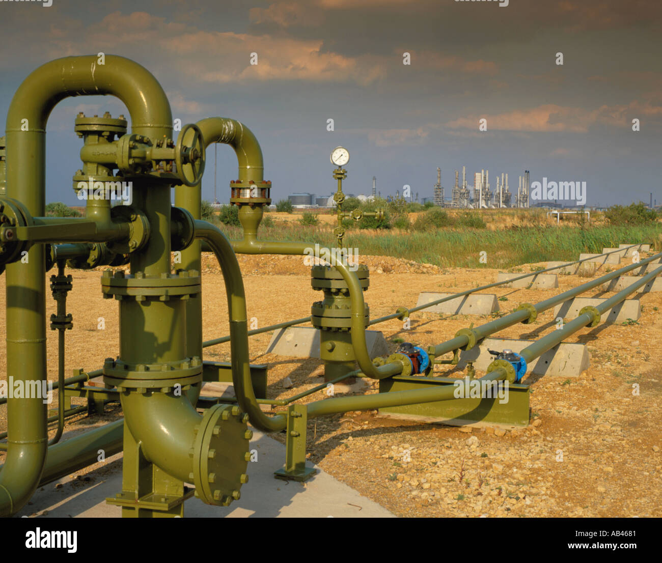 Pipework, taps, valves and gauges, with petrochemical refinery in the distance; Seal Sands, Teesside, Cleveland, England, UK. Stock Photo