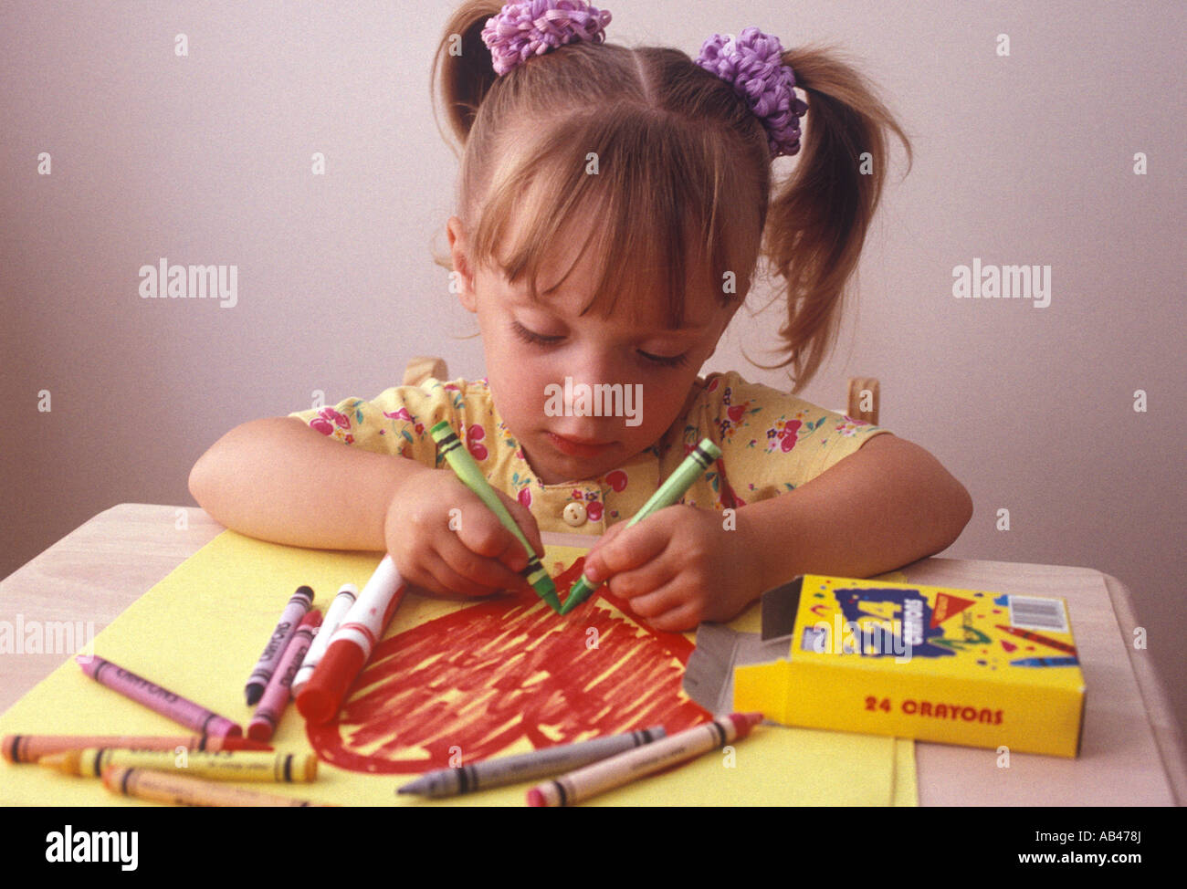 A young little girl coloring a picture with crayons Stock Photo - Alamy