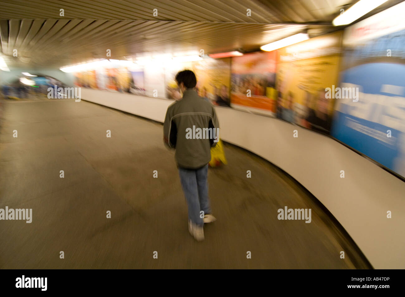 A young man walking in a subway tunnel Stock Photo