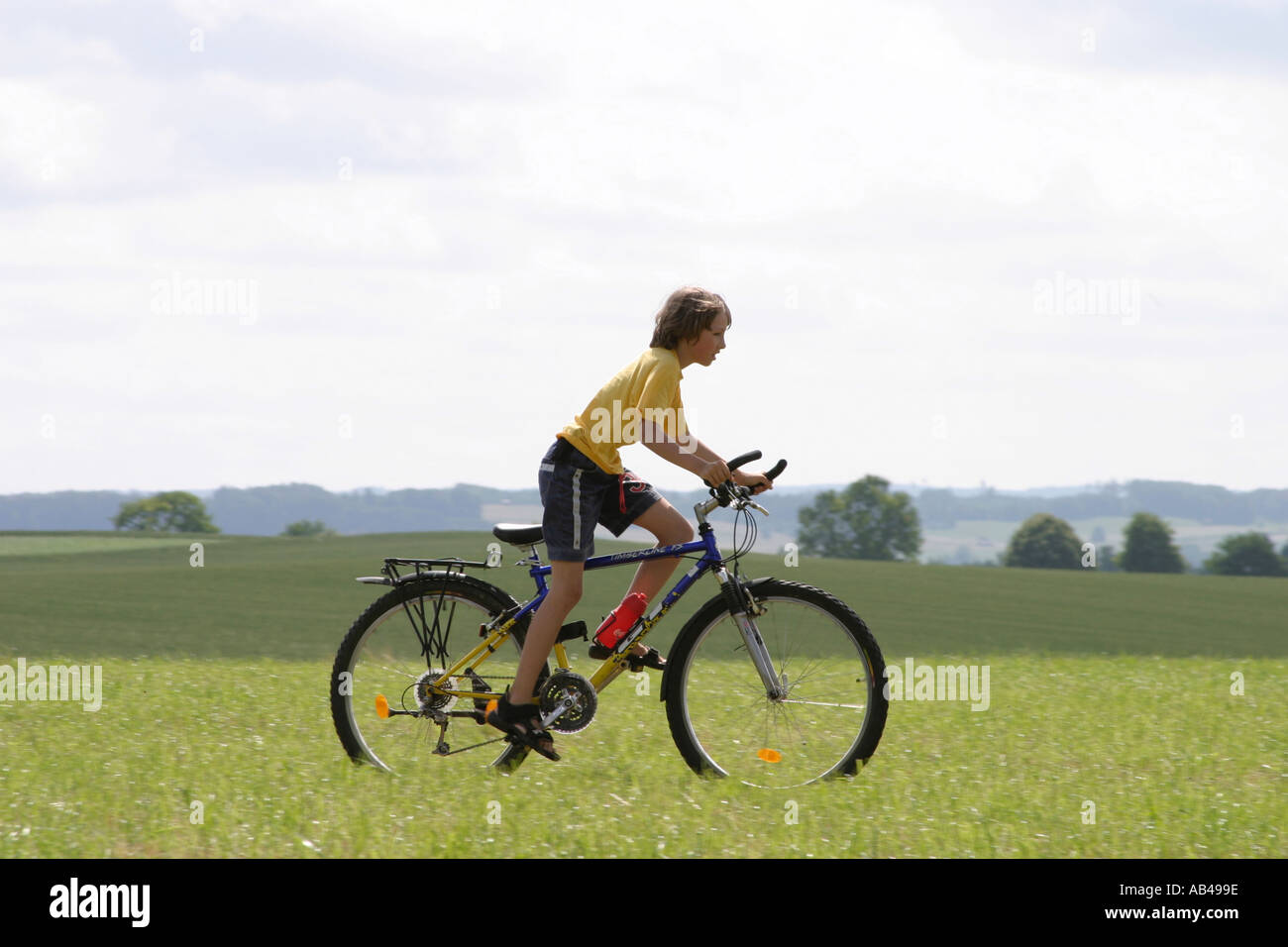 boy cicling over meadow Stock Photo
