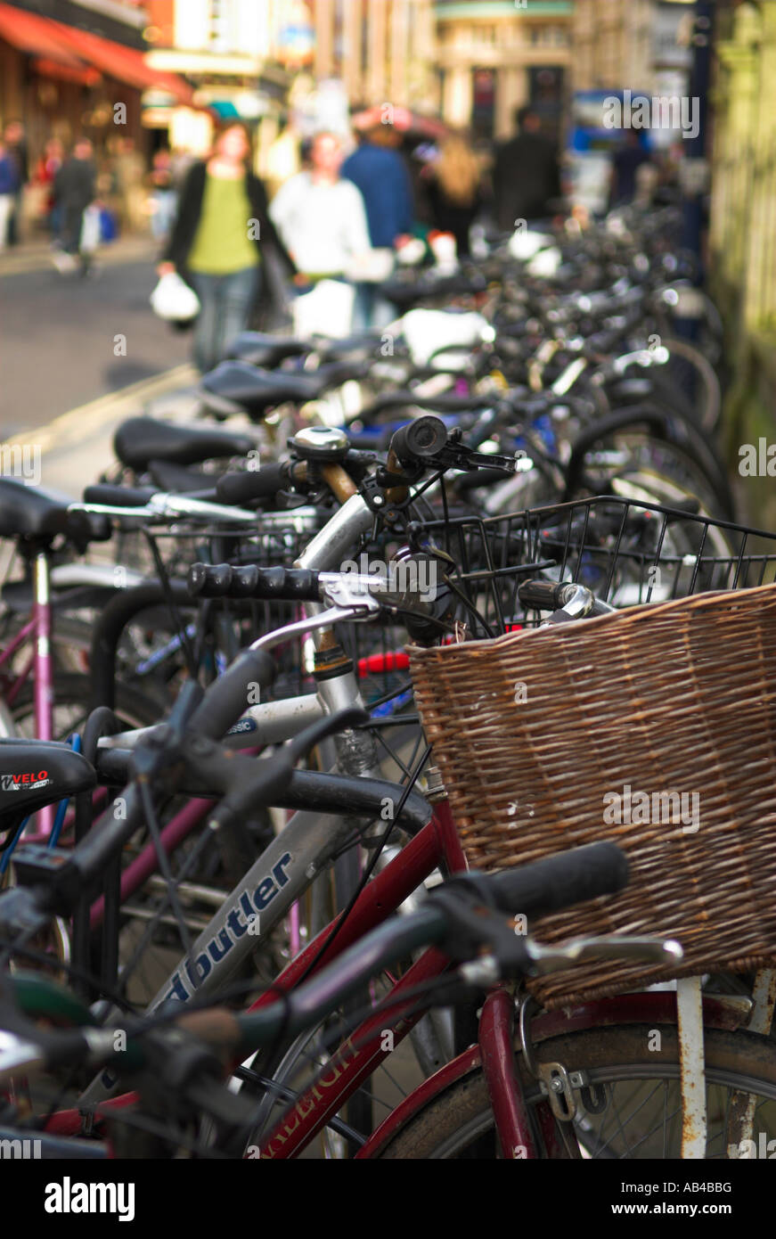 Row of bicycles parked on pavement along street Stock Photo